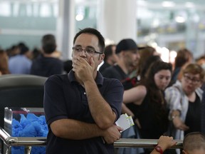 A passenger waits to pass the security control at the Barcelona airport in Prat Llobregat, Spain, Friday, Aug. 4, 2017. Security workers at Barcelona airport began partial strikes Friday which threatens more queuing chaos for passengers at one of Europe's most popular airports. (AP Photo/Manu Fernandez)