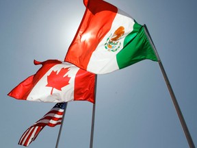 Flags of the United States, Canada, and Mexico fly as negotiations start for an update to the quarter-century-old North American Free Trade Agreement.