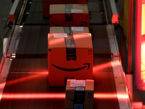 Amazon riding on a belt are scanned to be loaded onto delivery trucks.