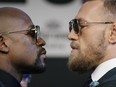 Floyd Mayweather Jr., left, and Conor McGregor pose for photographers during a news conference Wednesday, Aug. 23, 2017, in Las Vegas.