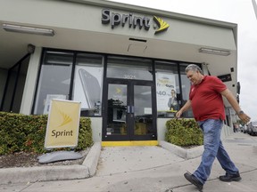 FILE - In this Friday, Oct. 28, 2016, file photo, a person walks by a Sprint store in Miami. On Tuesday, Aug. 1, 2017, Sprint Corp. reported fiscal first-quarter net income of $206 million, after reporting a loss in the same period a year earlier. The Overland Park, Kan.-based company said it had profit of 5 cents per share. The results beat Wall Street expectations. (AP Photo/Alan Diaz, File)
