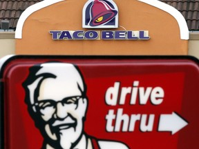 FILE - This Jan. 31, 2014, file photo, shows a Taco Bell facade behind a KFC drive-thru sign in Saugus, Mass. Yum Brands, Inc., which operates Taco Bell, KFC and Pizza Hut, reports earnings, Thursday, Aug. 3, 2017. (AP Photo/Elise Amendola, File)