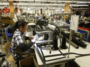 FILE - In this Wednesday, Aug. 31, 2016, file photo, a worker at the C.C. Filson Co. manufacturing facility stitches a belt at a sewing machine, in Seattle. On Thursday, Aug. 17, 2017, the Federal Reserve reports on U.S. industrial production for July. (AP Photo/Ted S. Warren, File)