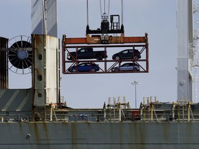 FILE - In this Thursday, July 13, 2017, file photo, a crane transporting vehicles operates on a container ship at the Port of Oakland, in Oakland, Calif. U.S. President Donald Trump and his economic advisers see the country's trade deficits as a sign of economic weakness. They point to 41 straight years of U.S. trade deficits as evidence that America has been out-competed, out-negotiated and flat out cheated by trading partners like China, Mexico and Germany, countries that consistently sell more to the United States than they buy. (AP Photo/Ben Margot, File)