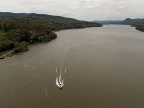 FILE - In this June 29, 2017 file photo, a recreational boater cruises along the Hudson River near Fort Montgomery, N.Y. When New York state officials release results of their own contamination testing of Hudson River, it could be the state's latest salvo against the EPA, which is defending a $1.5 billion Superfund cleanup of the river. (AP Photo/Julie Jacobson)