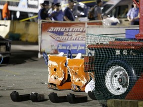 FILE-This Wednesday, July 26, 2017 file photo shows authorities standing near damaged chairs of the Fire Ball amusement ride after the ride malfunctioned injuring several at the Ohio State Fair in Columbus, Ohio. Authorities say there won't be any criminal charges in the deadly thrill ride accident at this year's Ohio State Fair. An 18-year-old high school student was killed and seven other people were hurt on the fair's opening day on July 26 when the Fire Ball ride broke apart as it was swinging with a full load of passengers. (Barbara J. Perenic/The Columbus Dispatch via AP, File)