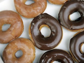 FILE - In this April 17, 2008, file photo, Krispy Kreme doughnuts are shown in Matthews, N.C. Krispy Kreme announced Aug. 9, 2017, that it's giving its signature glazed treats a chocolate sheen for the first time ever in honor of the Aug. 21 eclipse. (AP Photo/Chuck Burton, File)