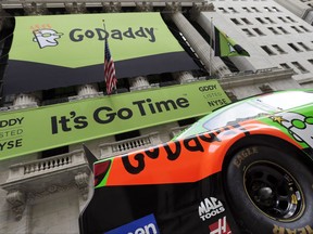 FILE - In this April 1, 2015, file photo, GoDaddy signage and a race car announce the company's IPO, in front of the New York Stock Exchange in New York. GoDaddy announced on Aug. 13, 2017, that has given a prominent white nationalist website that promoted a Virginia rally that ended in deadly violence 24 hours to move its domain to another provider because the site has violated GoDaddy's terms of service.  (AP Photo/Richard Drew, File)