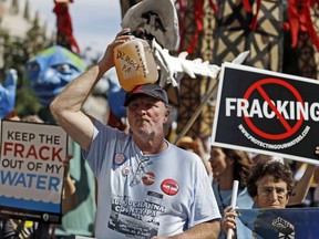 FILE – In this Sept. 20, 2012 file photo, Ray Kemble, of Dimock, Pa., holds a jug of his well water on his head while marching with demonstrators against hydraulic fracturing outside a Marcellus Shale industry conference in Philadelphia. Federal government scientists are collecting water and air samples in the first week of August 2017 from about 25 homes in Dimock, Pa., a tiny, rural crossroads about 150 miles north of Philadelphia that became a flashpoint in the national debate over fracking to investigate ongoing complaints about the quality of the drinking water. (AP Photo/Matt Rourke, File)