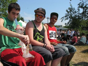 FILE--In this Aug. 17, 2012, file photo, Matt Galanti, 17, of Bothell, Wash., left, smokes marijuana from a glass bong at the opening day of the pro-marijuana rally Seattle Hempfest as friends Zach Casselman, 18, of Bothell, and Clay Graeber, 20, of Bothell, look on. Seattle on Tuesday, Aug. 8, 2017, agreed to drop a $1,000 fine issued to the nonprofit organization that runs HempFest--the annual summer marijuana celebration. The city accused the organization of operating a marijuana business without a license but later said it had no evidence the group violated the law. (AP Photo/Gene Johnson, file)