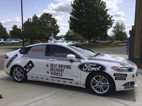 This Friday, Aug. 24, photo, shows the specially designed delivery car that Ford Motor Co. and Domino's Pizza will use to test self-driving pizza deliveries, at Domino's headquarters in Ann Arbor, Mich. Ford and Domino's are teaming up to test how consumers react if a driverless car delivers their pizzas. The car, which can drive itself but will have a backup driver, lets customers tap in a code and retrieve their pizza from a warming space in the back seat. (AP Photo/Dee-Ann Durbin)
