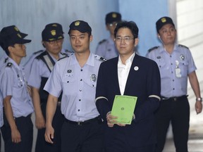 Lee Jae-yong, second from right, vice chairman of Samsung Electronics Co., arrives for his trial at the Seoul Central District Court in Seoul, South Korea, Monday, Aug. 7, 2017. South Korean prosecutors recommended imprisoning a billionaire Samsung heir for 12 years on Monday, asking court to convict him of bribery and other crimes in a national corruption scandal. (AP Photo/Ahn Young-joon, Pool)