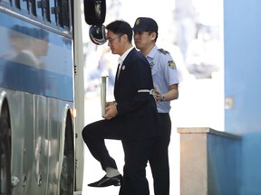 Jay Y. Lee, co-vice chairman of Samsung Electronics Co., front, is escorted by a prison officer as he boards a bus at the Seoul Central District Court in Seoul, South Korea, on Friday, Aug. 25, 2017.