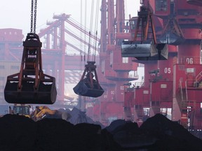 FILE - In this June 6, 2015, file photo, heavy machines move imported iron ore at the dock in Rizhao in eastern China's Shandong province.  China announced Monday, Aug. 14, 2017,  it will cut off imports of North Korean coal, iron ore and other goods in three weeks under U.N. sanctions imposed over the North's nuclear and missile programs.(Chinatopix via AP, File)