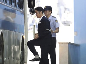 Samsung Electronics Co. Vice Chairman Lee Jae-yong, left, prepares to get on a vehicle as he leaves after his verdict trial at the Seoul Central District Court Friday, Aug. 25, 2017 in Seoul, South Korea. The court sentenced the billionaire Samsung heir to five years in prison for bribery and other crimes that fed public anger leading to the ouster of Park Geun-hye as South Korea's president. (Chung Sung-Jun/Pool Photo via AP)