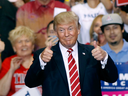 President Donald Trump gives a thumbs up to supporters at the Phoenix Convention Center during a rally on August 22