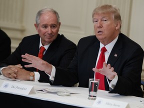 Blackstone CEO Stephen Schwarzman (left) and President Donald Trump attend a meeting with business leaders in the White House in February. The executive council, which is led by Schwarzman, planned to inform the White House Wednesday it was disbanding, sources say.