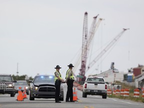 A roadblock is set up at the north end of the Bonner Bridge on Thursday, Aug. 3, 2017, on Hatteras Island, N.C. The outage caused by a construction accident forced an estimated 50,000 visitors to leave Hatteras and Ocracoke islands, and others never made it to the popular vacation spots because of evacuation orders that are still in place. (Steve Earley/The Virginian-Pilot via AP)