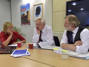 British Secretary of State for Exiting the European Union David Davis, center, speaks with Director General at the Department for Exiting the European Union Sarah Healey, left, and UK's Permanent Representative to the European Union Tim Barrow, right, during a meeting in Brussels on Wednesday, Aug. 30, 2017. (Eric Vidal, Pool Photo via AP)