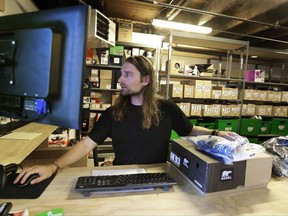 In this July 25, 2017, photo, Martin Goldman processes returned items in the Will Call department of evo, a Seattle-based outdoor, bike, ski, and clothing retailer. Customers can pick up online orders at the store without paying shipping charges, and evo also has arrangements with competing retailers to ship orders to their stores for pickup, as well. (AP Photo/Ted S. Warren)