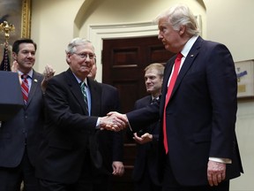 FILE - In this Feb. 16, 2017, file photo, President Donald Trump shakes hands with Senate Majority Leader Mitch McConnell of Ky., during a ceremony in the Roosevelt Room of the White House in Washington. Trump's attacks on McConnell come at the worst possible time, if the president's goal is actually to accomplish the agenda on health care, infrastructure and taxes he's goading his GOP ally to pass. Behind from left are Rep. Evan Jenkins, R-W.Va., and Rep. Jim Jordan, R-Ohio.(AP Photo/Carolyn Kaster, File)