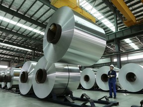In this Aug. 3, 2017 photo, a worker arranges the aluminum rolls at a factory in Suixi county in central China's Anhui province. China's trade growth weakened in July in a negative sign for the country's economic growth and global demand. Customs data on Tuesday, Aug. 8, 2017 showed growth in exports decelerated to 7.2 percent from June's 11.3 percent. Imports rose 11 percent, down from the previous month's 17.2 percent. (Chinatopix via AP)