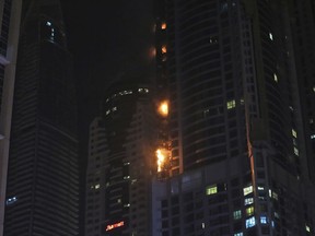 Smoke and fire rise from a high rise building at Marina district in Dubai, United Arab Emirates, Friday, Aug. 4, 2017. The high-rise residential tower has caught fire in the middle of the night, sending plumes of black smoke into the air and debris falling below. (AP Photo/Kamran Jebreili)