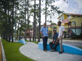 In this July 26, 2017 photo, Cuban architects Yasser Jimenez, left, Oriesky Bencomo, center, and Jose Luis Valdes, right, pose at the site  one of their urban designs in Pinar del Rio, Cuba. The central avenue of the western city of Pinar del Rio, population 150,000, was redesigned over the last three years by the architects contracted by the communist provincial government, a contract that would have been unimaginable in Cuba just a few years ago. (AP Photo/Ramon Espinosa)