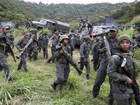 Soldiers break ranks after standing in formation behind Adm. Remigio Ceballos, chief of staff of the Venezuelan Armed Forces Strategic Operational Command, during a press conference to provide details of military drills that are being prepared in response to President Donald Trump's warning of possible military action, at Fort Tiuna, Caracas, Venezuela, Friday, Aug. 25, 2017. (AP Photo/Ricardo Mazalan)