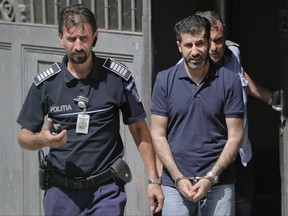 Tavan Resit, a Turkish businessman the United States wants to extradite on suspicion of supporting Iran's military procurement plan, walks handcuffed after asking a Romanian court to free him from arrest, in Bucharest, Romania, Thursday, Aug. 31, 2017. Resit was arrested on June 8 in Romania, where he had traveled to meet with U.S. officials. (AP Photo/Vadim Ghirda)