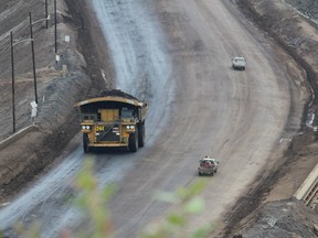 A heavy hauler drives past smaller trucks near the entrance of Suncor Energy's North Steepbank Mine, located north of Fort McMurray, Alta.