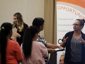 In this Thursday, Aug. 24, 2017, photo, Kathy Tringali, right, a recruiter for retailer Big 5 Sporting Goods, talks to job seekers during a job fair in San Jose, Calif. On Friday, Sept. 1, 2017, the U.S. government issues the August jobs report. (AP Photo/Marcio Jose Sanchez)