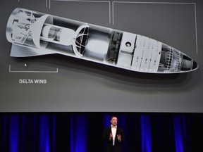 Elon Musk speaks in below a computer generated illustration of his new rocket at the 68th International Astronautical Congress 2017 in Adelaide on Friday.