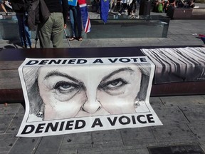 A poster showing British Prime Minister Theresa May is displayed during a protest staged by a group of UK citizens living in Italy, in Florence, Italy, Friday, Sept. 22, 2017.  British Prime Minister Theresa May, who is expected to deliver a speech about Brexit in Florence, will try Friday to revive foundering Brexit talks, and unify her fractious government, by proposing a two-year transition after Britain's departure from the European Union in 2019 during which the U.K. would continue to pay into the bloc's coffers. (Rosaria Caramiello/ANSA via AP)