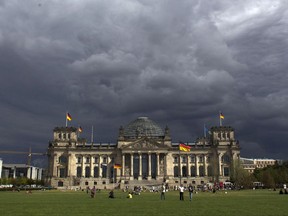 FILE In this Aug. 20, 2013 file photo dark clouds hang over the Reichstag, the German parliament Bundestag building, in Berlin, Germany. German officials say there's no sign of concerted cyberattacks aimed at influencing the outcome of the country's upcoming election, but are warning against giving the all-clear yet. Interior Minister Thomas de Maiziere told German daily Bild on Wednesday, Sept. 20, 2017, that the "we don't see that (Russian President Vladimir) Putin has meddled in the campaign." (AP Photo/Markus Schreiber, file)