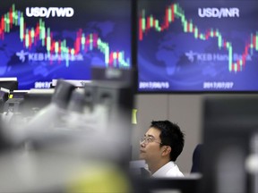 A currency trader looks at computer monitors near the screens showing the foreign exchange rates at their foreign exchange dealing room in Seoul, South Korea, Wednesday, Sept. 6, 2017. Asian stock markets were lower on Wednesday as investors found ample reasons to stay away from risky assets amid still-high tensions on the Korean Peninsula and the powerful hurricane approaching the United States. (AP Photo/Lee Jin-man)