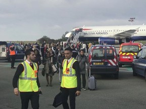 In this photo provided by James Anderson, people are evacuated from a British Airways plane, on the tarmac of Charles de Gaulle airport, in Paris, Sunday, Sept. 17, 2017.  Police and firefighters checked a British Airways plane on the tarmac of Paris' Charles de Gaulle airport Sunday morning after reports of a security threat but authorities determined it was a false alarm. James Anderson, a 20-year-old entrepreneur on the flight from Paris to London's Heathrow Airport, told The Associated Press that the pilot initially told passengers there were technical issues. ( James Anderson via AP)