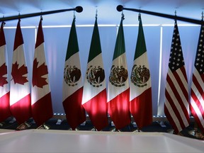 National flags representing Canada, Mexico, and the U.S. are lit by stage lights at the North American Free Trade Agreement, NAFTA, renegotiations, in Mexico City, Tuesday, Sept. 5, 2017. The second round of talks ended Tuesday, where relatively few concrete proposals appear to have been. (AP Photo/Marco Ugarte)