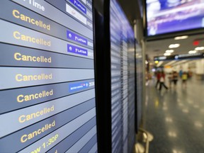 FILE - This Friday, Sept. 8, 2017, file photo, shows a monitor listing canceled flights at Miami International Airport in Miami. As of Monday, Sept. 11, 2017, airlines have canceled more flights as air travel in Florida remains grounded and Irma spins farther north. High winds have caused Delta and American to cancel many flights in Atlanta and Charlotte, N.C. Airlines hope to resume Miami flights Tuesday. (AP Photo/Wilfredo Lee, File)