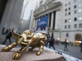 FILE - In this Tuesday, Oct. 25, 2016, file photo, a miniature reproduction of Arturo Di Modica's "Charging Bull" sculpture sits on display at a street vendor's table outside the New York Stock Exchange, in lower Manhattan.  U.S. stocks edged lower in early trading Thursday, Sept. 7, 2017, pulled down by insurers and other financial companies as investors weighed the prospects of big losses for the sector from Hurricane Irma.(AP Photo/Mary Altaffer, File)