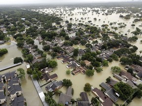 FILE - In this Tuesday, Aug. 29, 2017, file photo, water from Addicks Reservoir flows into neighborhoods as floodwaters from Harvey rise in Houston. Allstate expects $593 million in insurance losses for August due to Hurricane Harvey. That marks a spike from $181 million in July. The estimates do not include Hurricane Irma, which made landfall in September. (AP Photo/David J. Phillip, File)