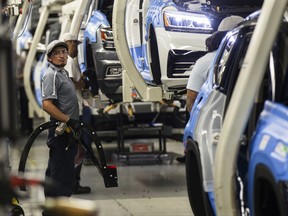 FILE - In this Thursday, Aug. 31, 2017, file photo, workers produce vehicles at Volkswagen's lone U.S. plant in Chattanooga, Tenn. U.S. industrial output plunged 0.9 percent in August, the most in eight years, mostly because of Hurricane Harvey's damage to the oil refining, plastics and chemicals industries. (AP Photo/Erik Schelzig, File)
