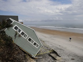 A house rests on the beach after collapsing off a cliff from Hurricane Irma in Vilano Beach, Fla., Friday, Sept. 15, 2017. Florida's economy has long thrived on one major import: people. Irma raised concerns about just how sustainable the allure of Florida's year-round warmth and lifestyle are. The wind, rain and flooding inflicted an estimated $50 billion in damage. (AP Photo/David Goldman)