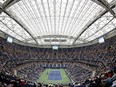 FILE- In this Sept. 6, 2017 file photo, fans fill the stands at Arthur Ashe stadium as Karolina Pliskova, of Czech Republic, plays CoCo Vandeweghe, of the United States, during the quarterfinals of the U.S. Open tennis tournament in New York. The arrest of an Estonian man for trespassing at the US Open has renewed questions about "courtsiding," the surreptitious collection of data for gamblers using online exchanges to bet point-by-point on tennis matches. (AP Photo/Adam Hunger, File)