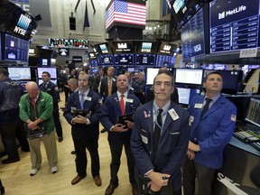 Traders on the floor of the New York Stock Exchange pause for a moment of silence on the 16th anniversary of the attacks on the World Trade Center, Monday, Sept. 11, 2017. (AP Photo/Richard Drew)