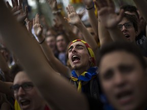 In this photo taken on Thursday, Sept. 21, 2017, people gesture and shout slogans during a protest in Barcelona, Spain. A confrontation between the central government in Madrid and independence movements in the wealthy northeastern Catalonia region has been gripping Spain for weeks. The conflict is due to come to a head on Sunday Oct. 1, 2017 when Catalonia intends to hold a regional ballot on whether to break away from the rest of Spain, despite government efforts to stop a vote being held. (AP Photo/Emilio Morenatti)