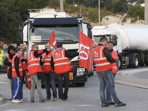 Members of the FO truckers trade union install a blockade at La Mede Total refinery, in Chateauneuf-La Mede, southern France, Monday, Sept. 25, 2017. French truck drivers plan nationwide protests against President Emmanuel Macron's changes to labor laws, as discontent builds over new rules that Macron says are essential to reviving the French and European economies. (AP Photo/Claude Paris)