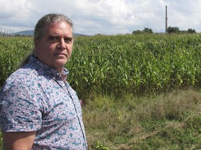 In this Sept. 15, 2017, photo, Rich Holschuh, a public liason for the Elnu Abenaki tribe, stands on a roadside near the Vermont Yankee nuclear plant, right rear, in Vernon, Vt. The Elnu is one of two Native American tribes who want a voice in the cleanup of the closed power plant and the future use of the land, which they say was the site of fishing grounds and settlements for their ancestors. (AP Photo/Lisa Rathke)