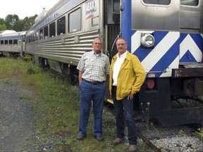 In this Sept. 5, 2017 photo, David Blittersdorf, right, and Charlie Moore pose in Barre, Vt., in front of one of a dozen passenger rail cars Blittersdorf bought to try to jump-start a commuter rail system in Vermont. Moore, a long-time rail expert in the state, is working to make that happen. (AP Photo/Wilson Ring)