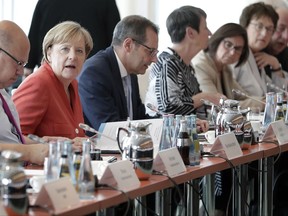 German Chancellor Angela Merkel, 2nd left, smiles prior to a meeting of the German government with  mayors of various German cities in Berlin, Germany, Monday, Sept. 4, 2017 on air quality protection. (AP Photo/Michael Sohn)